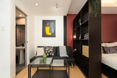 a living room with a couch and a table at Tranquil Greenbelt Makati Condo - Free Pool Access in Manila