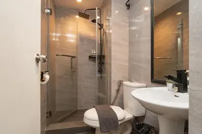 a bathroom with a shower and a toilet and a sink at Tranquil Greenbelt Makati Condo - Free Pool Access in Manila
