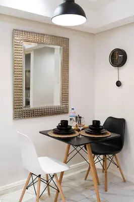 a dining room table with two chairs and a mirror at Greenbelt Makati Condo with Balcony & Park Views in Manila