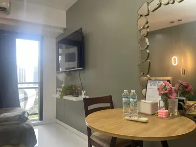 a dining room with a table and a mirror at Studio for 4 with Netflix, 55in TV, 200Mbs net, in heart of Makati in Manila