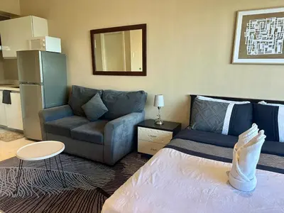 a living room with a bed and a couch at Studio Unit with Balcony in The Gramercy Residences in Manila