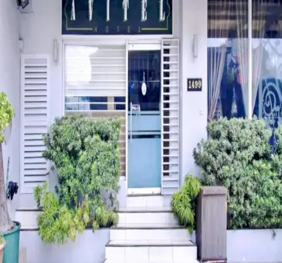 a white house with a blue door and some plants at Collection O Avitel Hotel near Osmena Highway, PNR Pasay Station, Metro Manila in Manila