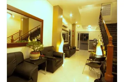 a living room with two couches and a staircase at Collection O Avitel Hotel near Osmena Highway, PNR Pasay Station, Metro Manila in Manila