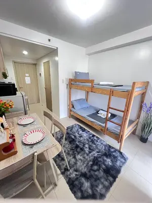 a living room with a table and a bunk bed at Unistay Shore Res with Bal Manila Bay View nr MOA in Manila