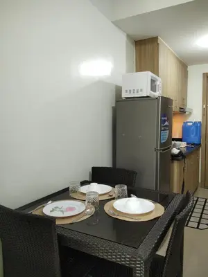 a kitchen with a table with two plates and a refrigerator at Shore2 tower2 in Manila