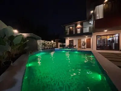 a swimming pool with green lighting in front of a house at Villa Serene Resort in General Trias