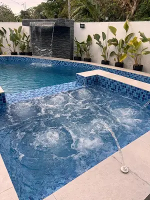 a swimming pool with a water fountain in the middle at Villa Serene Resort in General Trias