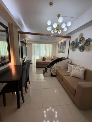 a living room with a couch and a dining room at Staycation By Abby Tower E in Manila