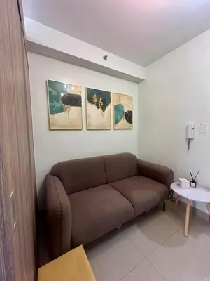 a living room with a couch and some pictures on the wall at Chic Urban Retreat near mall of asia in Manila