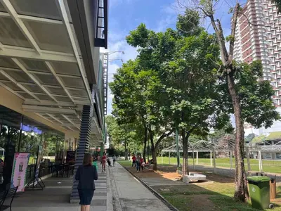 a woman walking down a sidewalk next to a building at Ortigas Business District Prime Accommodations in Manila