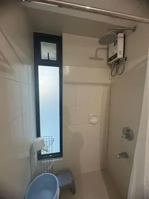 a bathroom with a shower and a toilet and a window at FLAIR Condotel 1 BR Near MRT EDSA Shangrila Megamall Lightmall in Manila