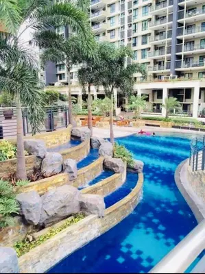 a swimming pool with blue water in a resort at FLAIR Condotel 1 BR Near MRT EDSA Shangrila Megamall Lightmall in Manila