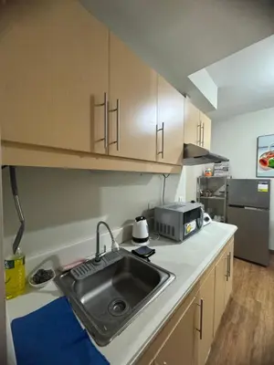 a kitchen with a sink and a microwave at FLAIR Condotel 1 BR Near MRT EDSA Shangrila Megamall Lightmall in Manila