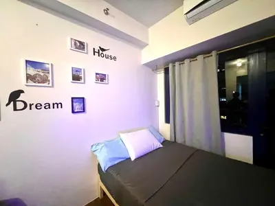 a bedroom with a bed and a dream sign on the wall at Makati Business District Prime Accommodations in Manila