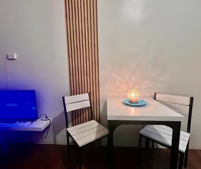 a table and chairs with a candle and a laptop at Makati Business District Prime Accommodations in Manila
