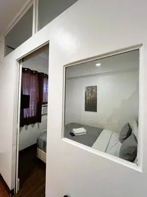 a room with a window with a bed in it at BGC Suites EDSA Makati in Manila