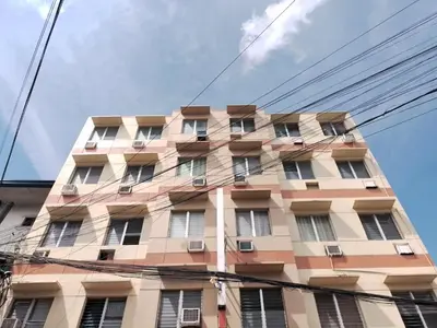a tall building with windows on the side of it at BGC Suites EDSA Makati in Manila