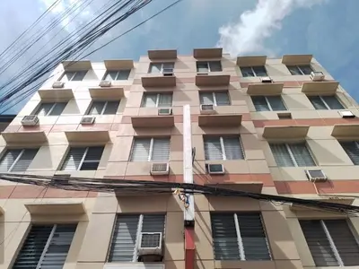 a tall building with windows on the side of it at BGC Suites EDSA Makati in Manila