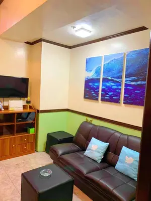 a living room with a couch and a flat screen tv at Somerset Condominium Kitchen Pool NAIA MOA LRT in Manila