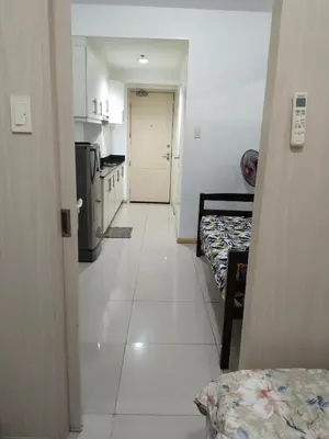 a room with a hallway with two beds and a kitchen at Mall Of Asia Sea Condotel in Manila