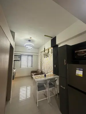 a kitchen and living room with a table and a couch at Leaf Residences Alabang Muntinlupa Condotel in Manila