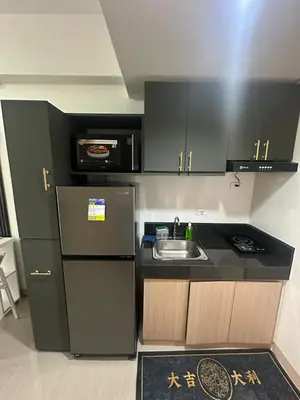 a small kitchen with a sink and a refrigerator at Leaf Residences Alabang Muntinlupa Condotel in Manila