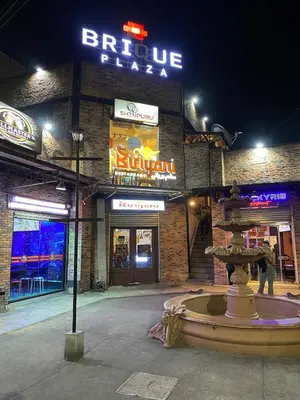 a building with a fountain in front of it at night at Elegant Escape Milano Bacoor Cavite in Bacoor