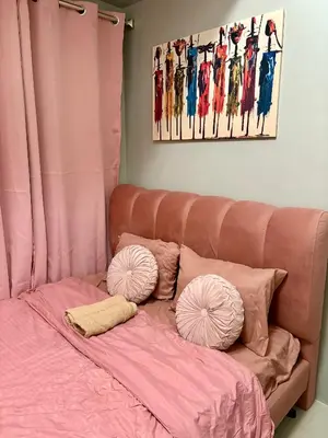 a bed with pink sheets and pillows on it at Comfy Cozy Staycation in Manila