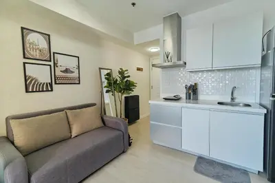 a living room with a couch and a kitchen at Bahamas Tower Azure Urban Resort Residences by Nestled Nook in Manila