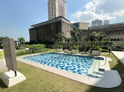 a swimming pool in the yard of a building at StayCation at Red Residence in Manila