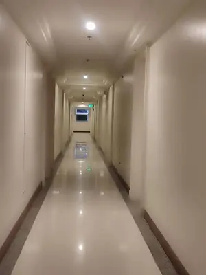an empty corridor with white walls and a long hallway at BP1043 Pool View Staycation Paranaque Pasay in Manila