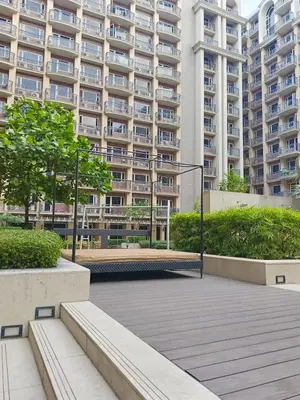 a large apartment building with a park in front of it at BP1043 Pool View Staycation Paranaque Pasay in Manila