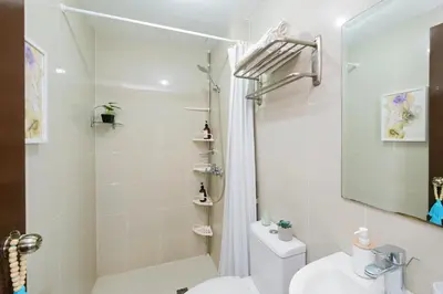 a bathroom with a shower and a toilet and a sink at Manhattan Heights Modern Studio in Manila
