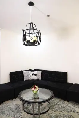 a living room with a black couch and a glass table at Home Away From Home in Manila