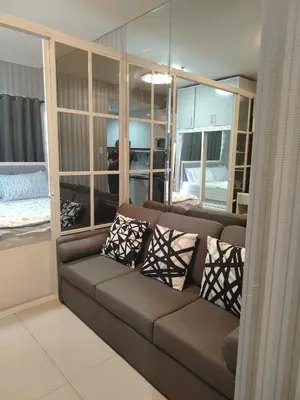 a living room with a brown couch and pillows at Shell Residence by Jas O in Manila