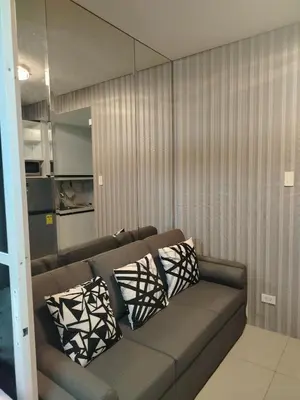 a living room with a couch with pillows on it at Shell Residence by Jas O in Manila