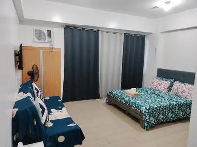 a bedroom with a bed and a couch in it at Kylie and Drew Room Near Airport in Manila