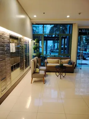 a lobby with couches and chairs in a building at Kylie and Drew Room Near Airport in Manila