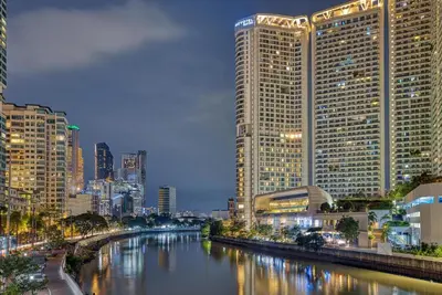 a city with tall buildings and a river at night at Novotel Executive Suite - Acqua Manila 2905 in Manila