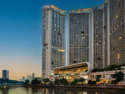 two tall skyscrapers in a city next to a river at Novotel Executive Suite - Acqua Manila 2905 in Manila