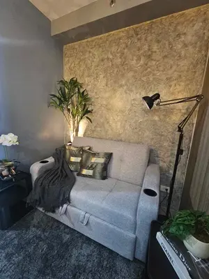 a living room with a couch and a lamp at Sakura Suites At Mall of Asia Near Airport in Manila