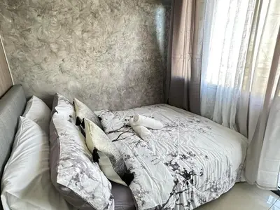 a bed with a teddy bear sitting on top of it at Sakura Suites At Mall of Asia Near Airport in Manila