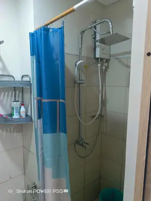 a shower in a bathroom with a blue shower curtain at SMDC Field REsidences condo unit in Manila