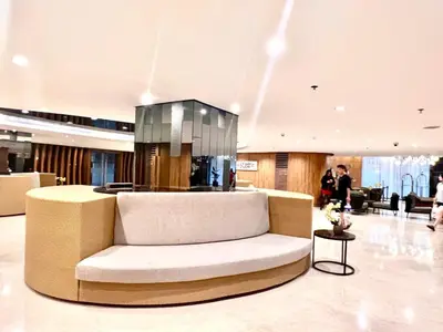 a lobby with a couch in the middle of a building at Very Central Mall of Asia Manila Apartment in Manila