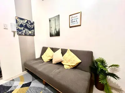 a couch in a living room with yellow pillows at MOA - Walking Distance to Mall Cheap Accommodation in Manila