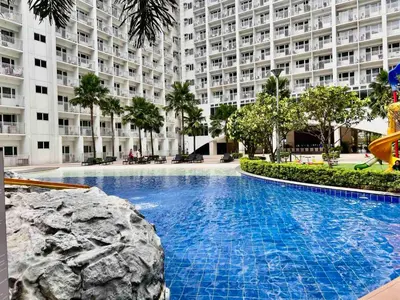 a large swimming pool in front of a large building at MOA - Aseana Value for Money Super Cozy Condo in Manila