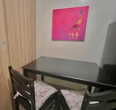 a table with a chair and a painting on the wall at MOA - Aseana Value for Money Super Cozy Condo in Manila