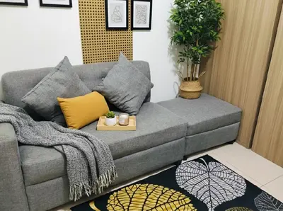 a living room with a grey couch with a table at Mall Of Asia - Aseana Super Value for Money in Manila