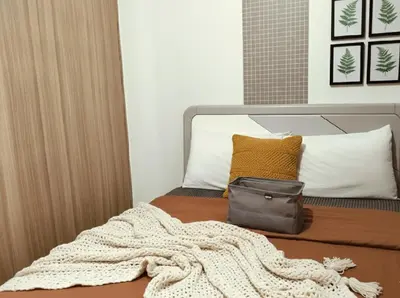 a bed with a blanket and a bag on it at Mall Of Asia - Aseana Super Value for Money in Manila