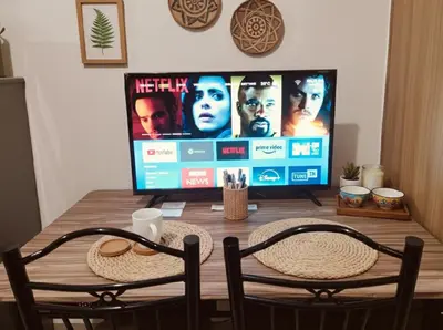 a television sitting on top of a wooden table with two chairs at Mall of Asia - Aseana Super Cheap Accommodation in Manila